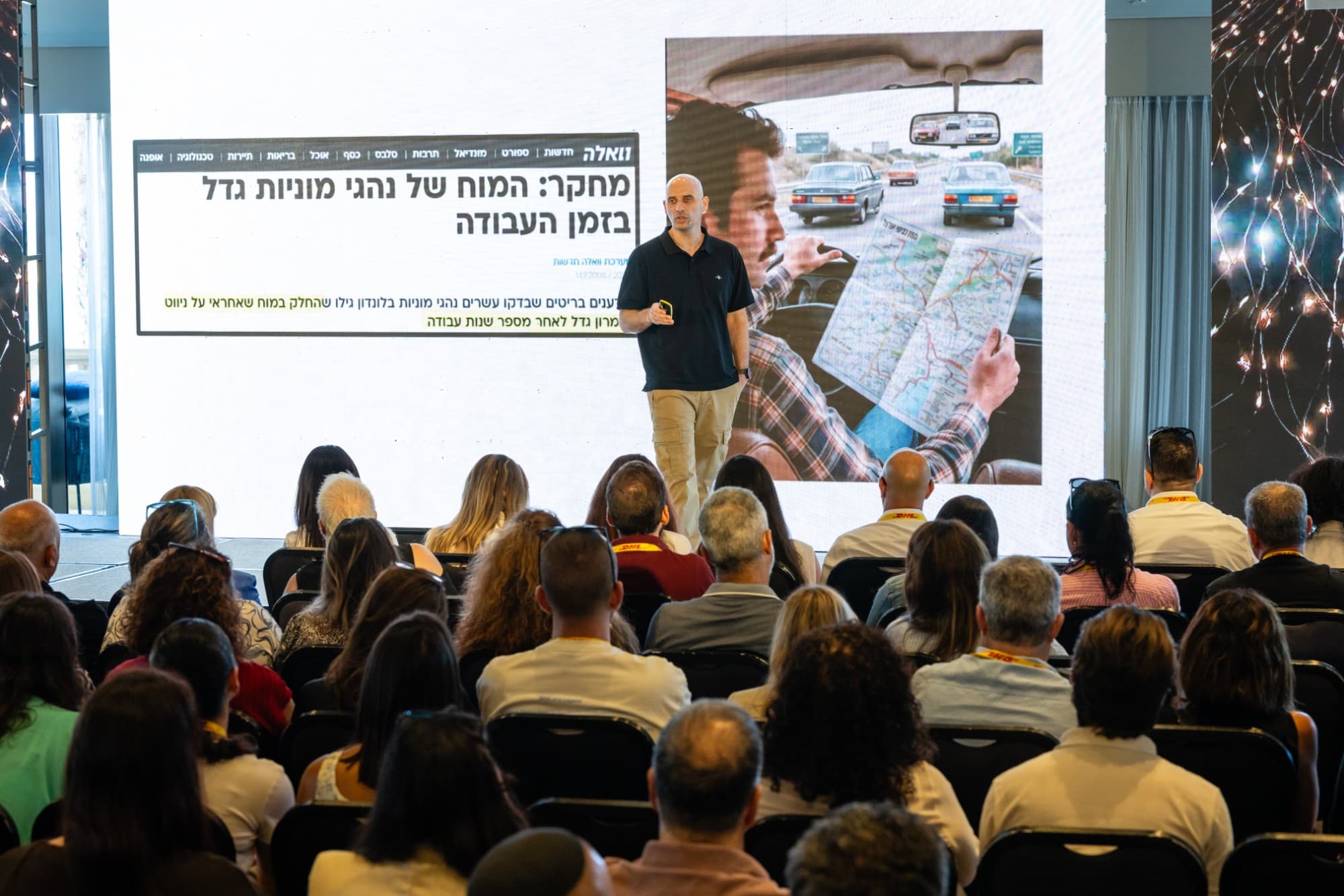 אייל גונן על הבמה בהרצאה על החיכוך האנושי בעידן ה-AI, מול קהל